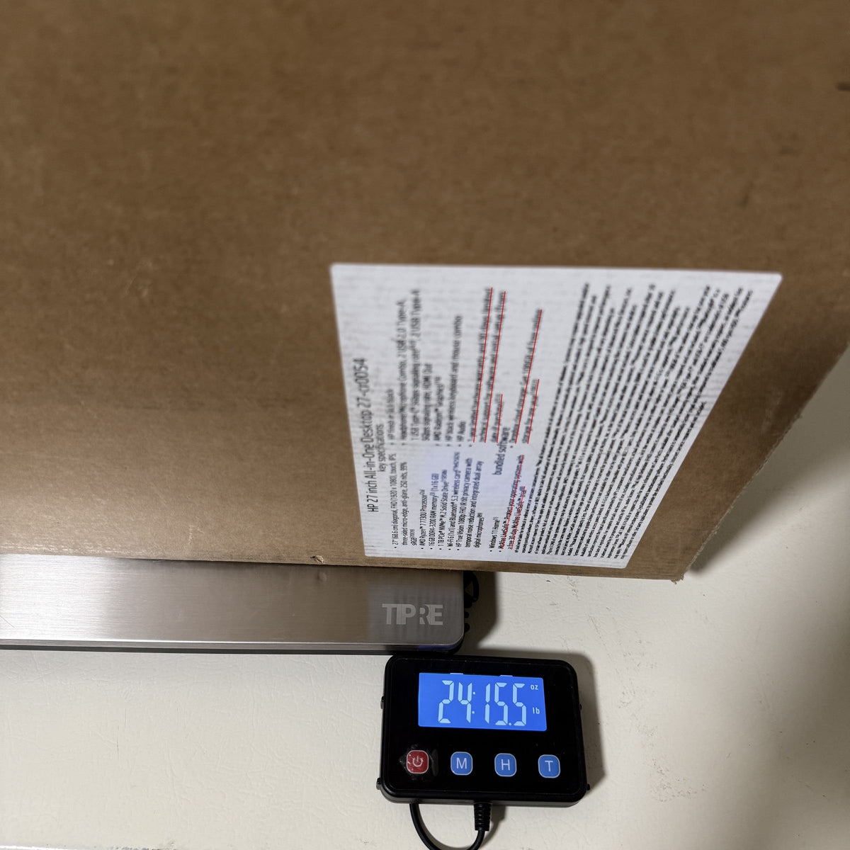 HP all-in-one carton on a digital scale reading 24 lb 15.5 oz