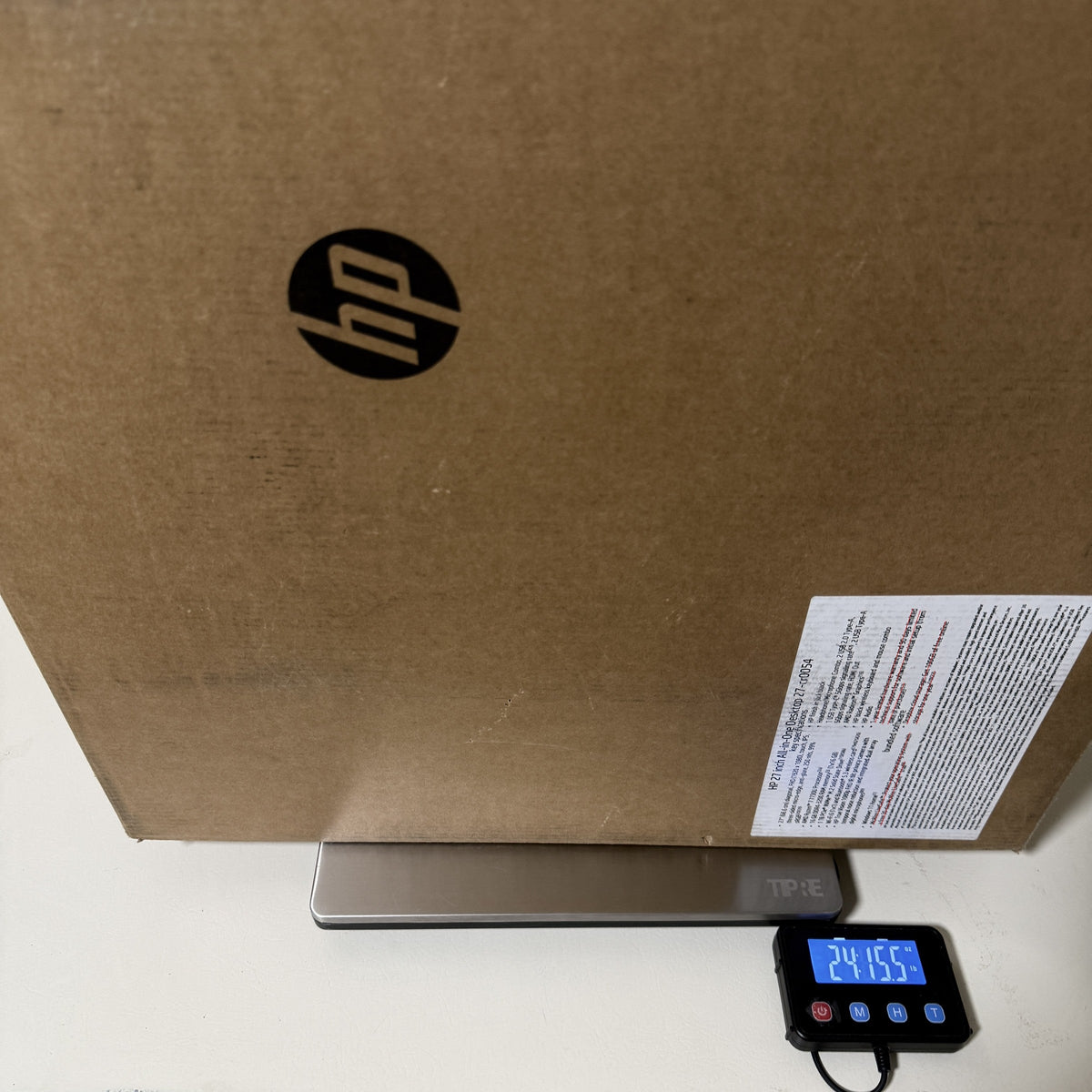 HP all-in-one carton on a digital scale, HP logo panel facing out