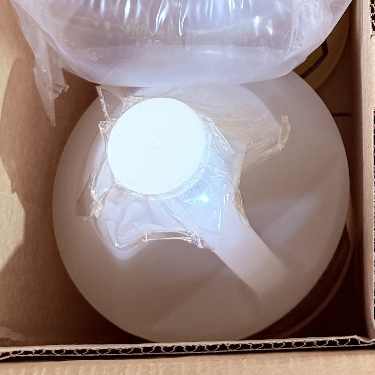 Southern Snow Imitation Cheesecake gallon jug packed upright in a shipping box, plastic overwrap on the cap