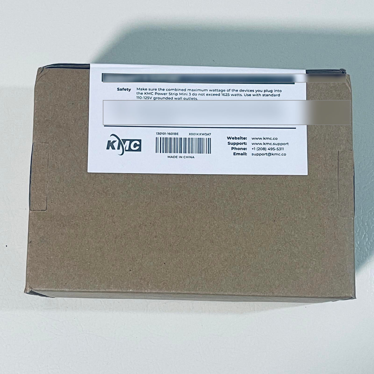 KMC Power Strip Mini 3 box label with safety wattage limits and manufacturer contact information